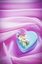 Blue gift box with present on pink fabric background holidays concept
