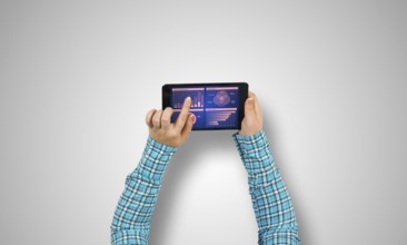 Top view of girl hands using tablet pc with diagrams and graphs on screen