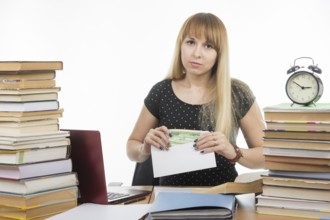 Upset girl student puts money in an envelope to bribe the teacher in the exam