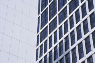 Close up detail of tall high rose modern apartment buildings with white cladding and dark windows