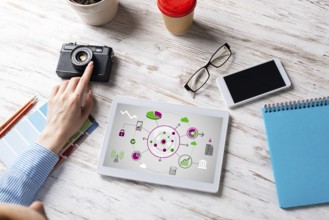 Blogger sitting at desk with tablet computer and camera. Mobile smart devices in business processes