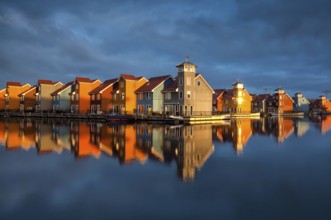 Beautiful colorful buildings on water in gold sunshine, Reitdiephaven, Groningen, Netherlands