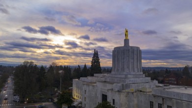 The state capital building adorned with the Oregon Pioneer with downtown Salem in the background