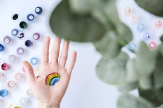 Rainbow LGBTQ flag painted on hand. Support for lgbt community. Honour of pride month. Connecting