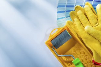 Color palette paint roller tray safety gloves on white surface