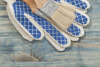 Paintbrushes protective gloves on wooden board construction concept