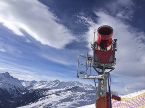 Modern red snow cannon near the ski piste in the high mountains