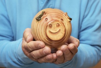 Senior holding piggy bank in hands