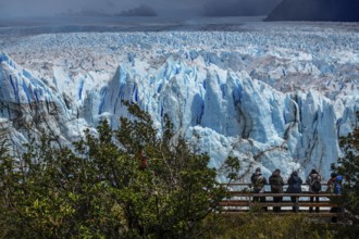 Tourists on wooden plank paths photographing the Perito Moreno glacier, glacier tongue, glacier