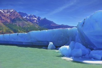 Ices and sun of Patagonia. White-blue huge icebergs float near a ship board. Excursion by tourist
