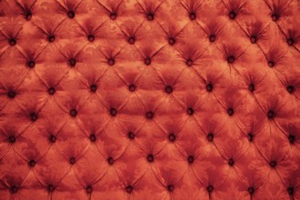 Close up background texture of scarlet red capitone genuine leather, retro Chesterfield style soft
