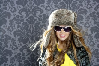 Children fashion blond girl with fur winter coat sunglasses and hat