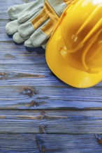 Protective gloves hard hat on vintage wooden board