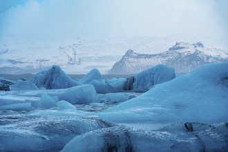 Serene icy landscape with blue glaciers and snowy mountains, with a cold wintry atmosphere, iceberg