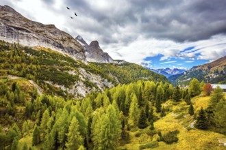 Autumn day. The shores of the glacial lake in the Dolomites. On the mountain slopes there is a