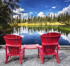 Jasper National Park in the Rocky Mountains. Two red plastic chairs on the lake. On shores of the