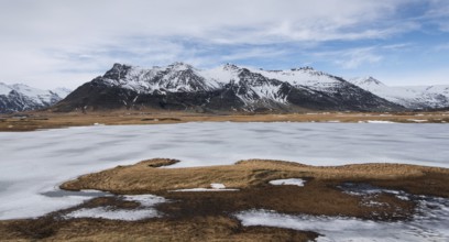 Typical Icelandic mountain landscape in Southeast Iceland with frozen lake