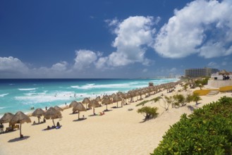 Umbrellas on a sandy beach with azure blue water on a sunny day near Cancun, Mexico, Central