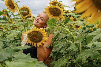A stunning blonde model gracefully poses in a vibrant sunflower field, basking in the warmth of a