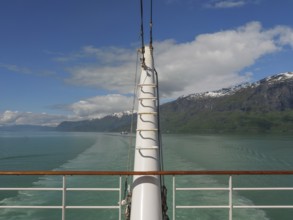 View from a boat access area over green water and surrounded by mountains and clouds, sailing in a