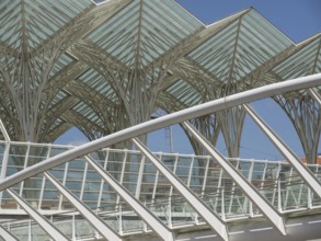Architectural details of a modern structure with glass roof and steel construction against blue