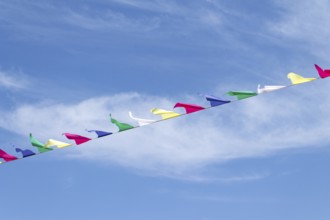 Multi-colored flags on a rope against the blue sky
