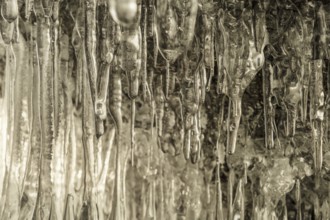 Ice cave on Baikal lake in winter. Clear transparent ice and icicles in grotto. Olkhon island,