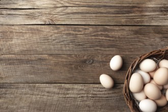 Organic chicken eggs in basket on wooden background. Organic household concept with eggs from