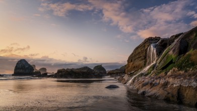 A seascape sunset with a waterfall at the beach. Humboldt County, California