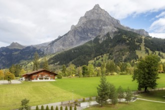 Wooden chalet in Kandersteg village, Canton Bern, Switzerland, Europe, Autumn trees and mountains