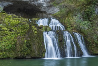 Waterfall from the source of the Lison in a haven of peace with its waterfall surrounded by forest.