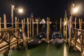Venetian gondolas, boat dock at St Mark's Square, church of San Giorgio Maggiore in the background,
