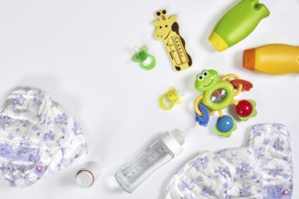 Set of accessories for baby. Pacifier, bottle, diaper, cream on white background. Maternal concept