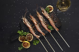 Grilled shrimp skewers. Seafood, shellfish. Shrimps Prawns skewers with herbs, garlic and lemon on