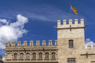 Tower with the flag of Valencia on the richly decorated brick building of the Algemesí School in Pl