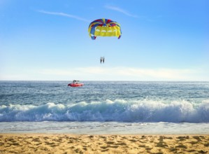 Parasailing over sea in sunny summer day