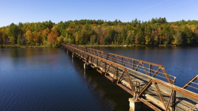 Fall color has begun to appear in the trees around a like in the Adirondacks