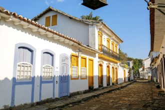 Typical colonial two and one story houses with colorful doors and windows on sunny day in historic