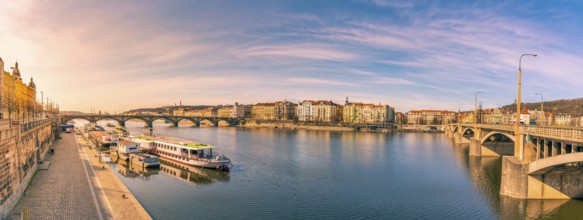 Colorful panorama with the Vltava river, its bridges and the buildings of Prague city, on a sunny