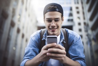 Man Sitting Listening Music Earphones Concept. Cheerful young guy listening the music