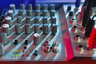 Audio mixer music desk under colorful lights equipment