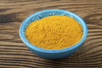 Curcuma powder in a small bowl on the table