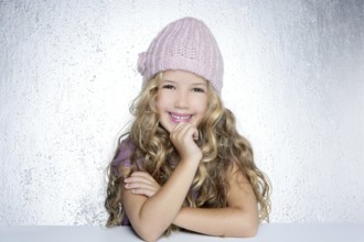 Smiling gesture little girl winter pink cap portrait silver background