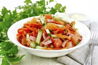 Salad from smoked sausage, spicy carrot, tomato, cucumber and spices with mayonnaise, kitchen