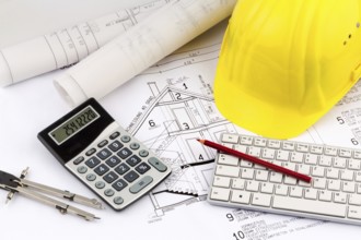 An architect's construction plan with a builder's helmet. Symbolic photo for financing and planning