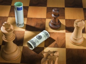 Chess with dollar and euro banknote. Symbol for devaluation of the dollar against the euro. Austria