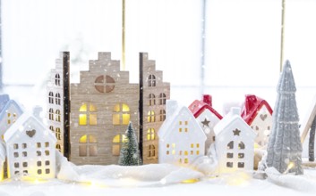 Cozy Christmas decor tiny house of small size on window sill with snow outside the window. Gift for