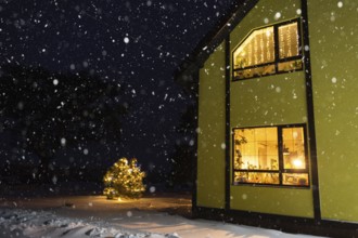 Cozy festive window of the house outside with the warm light of fairy lights garlands inside,