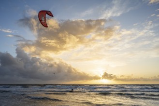 A kitesurfer in the distance at sunset over the sea, impressive cloud formations, Texel