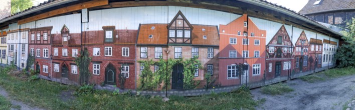 Panoramic photo of garage doors, with graffiti facades of buildings from the medieval old town of